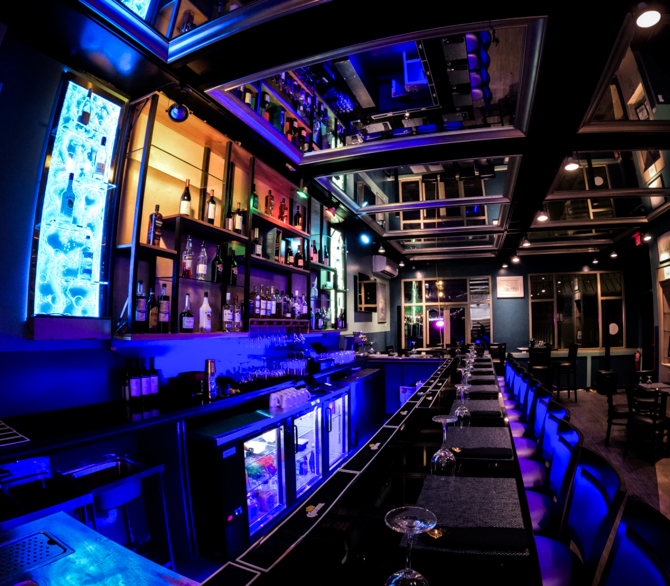 The SeaRock bar at night - backlit spirits wall washed in deep blue light