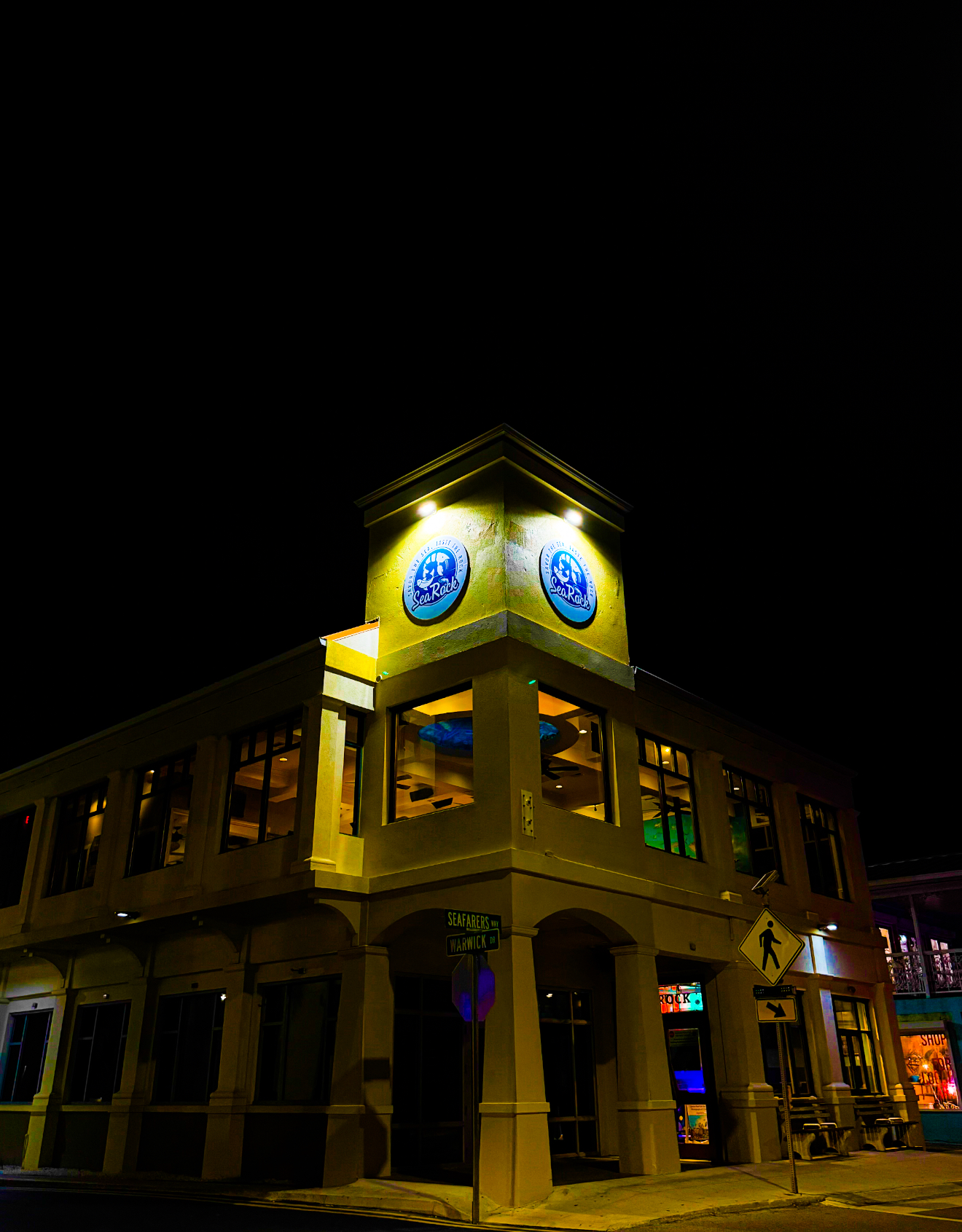 SeaRock's corner building lit up at night on Seafarers Way, George Town