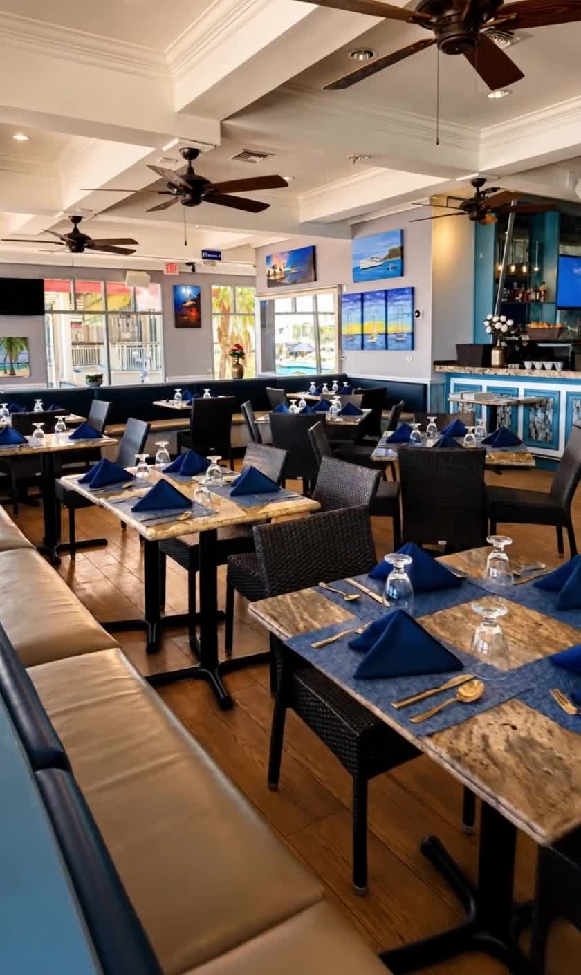 The SeaRock dining room - blue-and-gold tables, ceiling fans and George Town harbour light